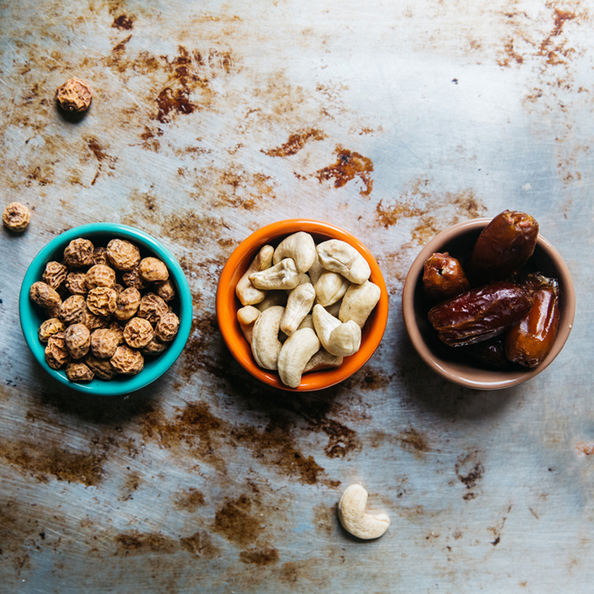 three colorful bowls with peanuts, cashew nuts 